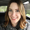 Smiling woman feeling refreshed after a pain-free sleep with CerviSleep™ pillow.