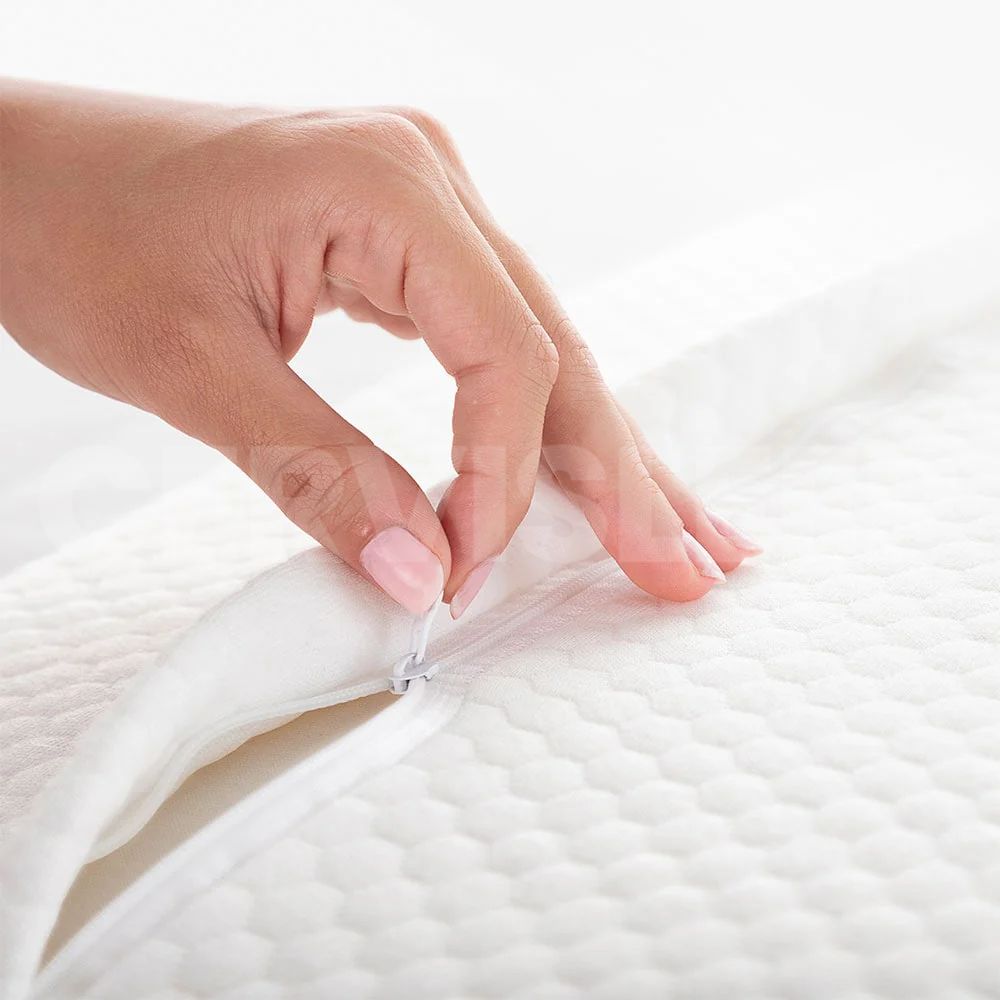 Hand unzipping the CerviSleep™ pillow cover to reveal breathable, adjustable memory foam layers.