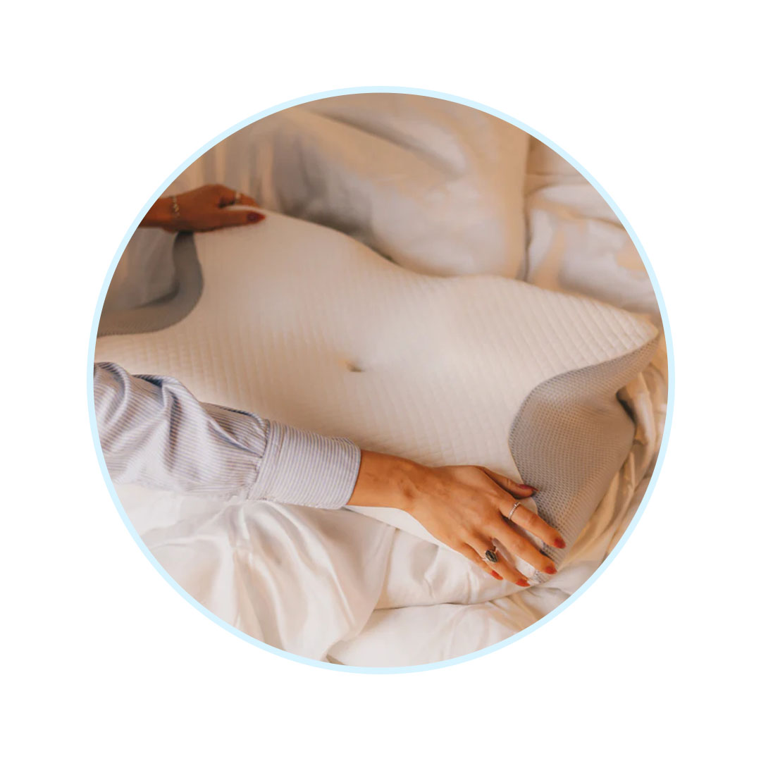Woman placing CerviSleep™ orthopedic pillow on the bed for neck pain relief and better sleep.